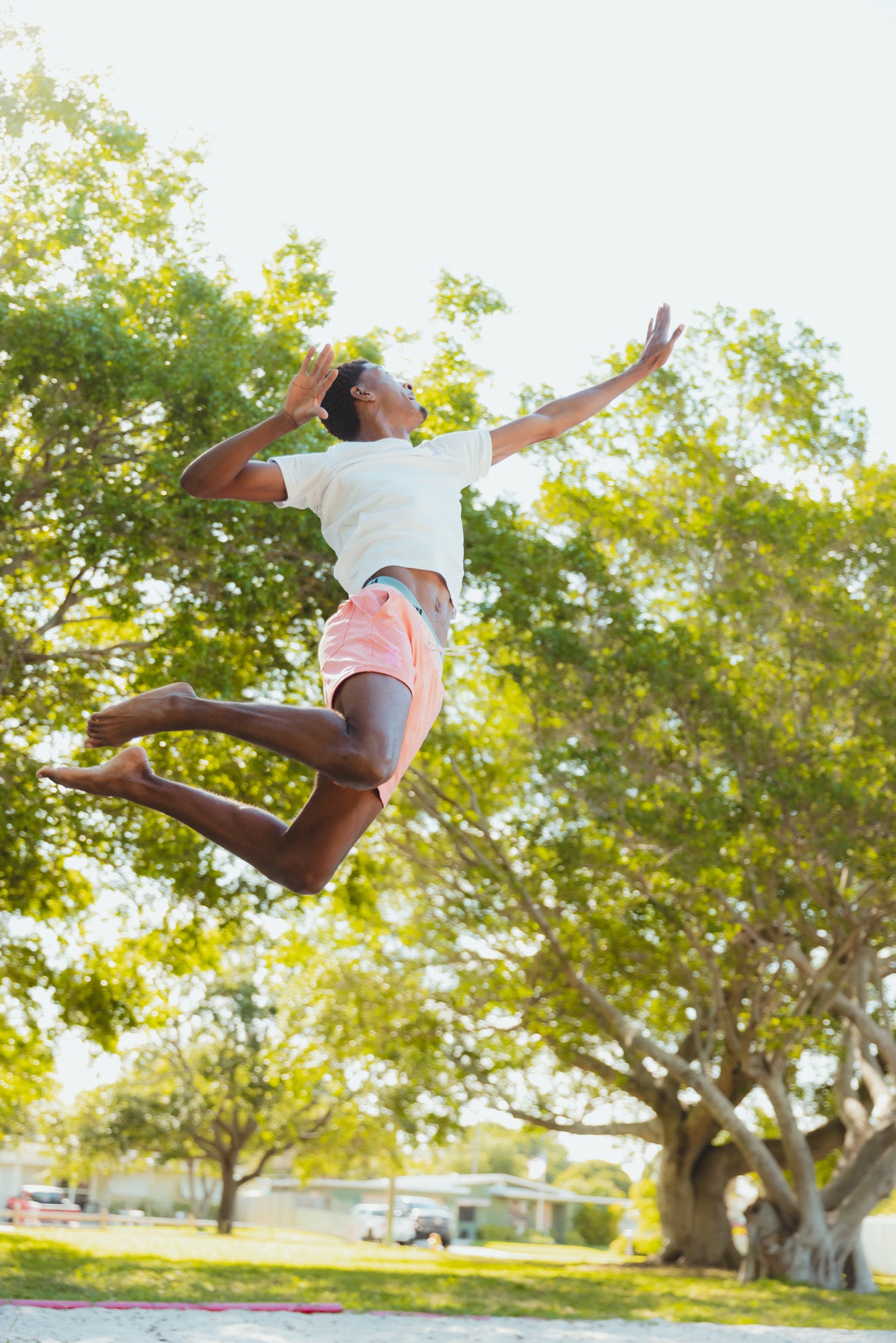 Person jumping in the air with trees in the background