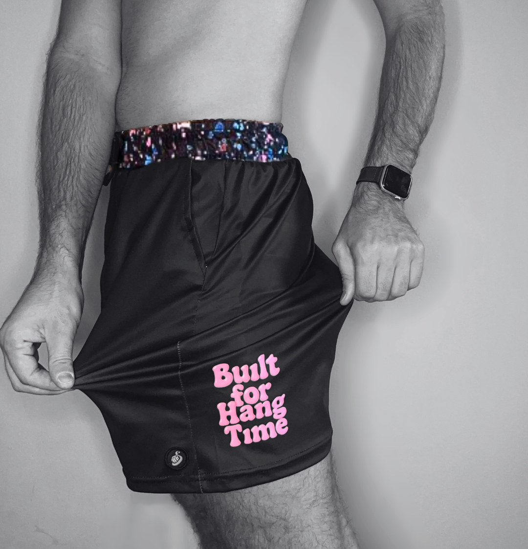 Black shorts with pink text 'Built for Hang Time' and colorful waistband on a gray background